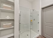 Thumbnail 38 of 60 - A white bathroom with a glass shower door and a white towel.
