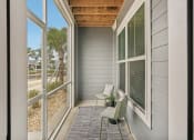 Thumbnail 14 of 58 - a covered porch with two chairs and sliding glass doors at Palm Grove in Ellenton, FL