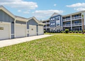 Thumbnail 39 of 124 - Private garages with driveways and apartment community buildings at Velara Luxury Apartments, Florida