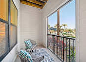 Thumbnail 35 of 60 - A balcony with a chair and a pillow.
