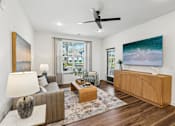 Thumbnail 7 of 124 - Living room with wood media console and ocean artwork at Velara Luxury Apartments, Ponte Vedra Beach, FL 32081