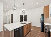 Thumbnail 50 of 60 - A kitchen with a black fridge and wooden cabinets.