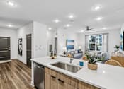 Thumbnail 46 of 124 - Kitchen island with sink overlooking living area at Velara Luxury Apartments, Ponte Vedra Beach, 32081