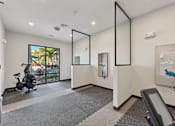 Thumbnail 19 of 60 - A room with a treadmill and a mirror on the wall.