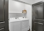 Thumbnail 49 of 124 - Laundry nook with white washer and dryer at Velara Luxury Apartments, Florida
