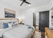 Thumbnail 50 of 124 - Bedroom with wooden bed frame and ceiling fan at Velara Luxury Apartments, Florida, 32081