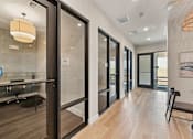 Thumbnail 39 of 60 - A modern office space with glass walls and wooden floors.