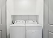 Thumbnail 45 of 62 - Two white front loading washing machines in a laundry room.