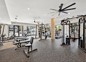 Thumbnail 31 of 60 - A gym with a variety of equipment including treadmills, weights, and a bench press.