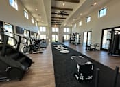Thumbnail 4 of 40 - A gym with treadmills, elliptical machines, and other exercise equipment.