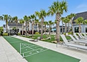 Thumbnail 46 of 54 - A tennis court is surrounded by palm trees and lounge chairs.