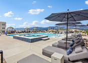 Thumbnail 1 of 24 - A pool area with sun loungers and umbrellas.