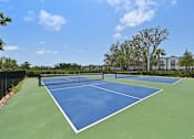 Thumbnail 68 of 68 - A tennis court with blue and green surface and white lines. at The Sophia, Venice, FL