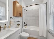 Thumbnail 51 of 58 - a white bathroom with white subway tile and a shower and a sink and a toilet at Meridian at CityPlace, Woodbury, MN 55125