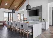 Thumbnail 14 of 46 - a kitchen with a marble counter top and a long island with chairs at Alta25, Monument