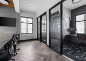 Thumbnail 30 of 46 - a conference room with a desk and chairs and sliding glass doors at Alta25, Monument, CO