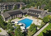 Thumbnail 1 of 4 - A large building with a pool and tennis court in front.