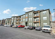 Thumbnail 58 of 59 - a parking lot full of cars in front of a building at The Quarry Luxury Apartment Homes, Fort Collins, CO