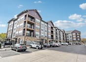 Thumbnail 59 of 59 - a large apartment building with cars parked in a parking lot at The Quarry Luxury Apartment Homes, Colorado