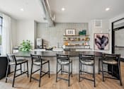 Thumbnail 28 of 59 - a kitchen with a large island with four stools at The Quarry Luxury Apartment Homes, Fort Collins, CO
