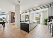 Thumbnail 25 of 59 - a kitchen with a large island in the middle of a room at The Quarry Luxury Apartment Homes, Fort Collins, Colorado