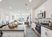 Thumbnail 4 of 59 - an open kitchen and living room with a large counter top at The Quarry Luxury Apartment Homes, Fort Collins, CO