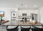 Thumbnail 6 of 59 - a kitchen and dining room with a table and chairs at The Quarry Luxury Apartment Homes, Fort Collins, 80526