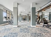 Thumbnail 46 of 59 - a gym with exercise machines and a blue and white carpet in a building at The Quarry Luxury Apartment Homes, Fort Collins, CO, 80526