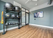 Thumbnail 50 of 59 - a fitness room with weights and a television on the wall at The Quarry Luxury Apartment Homes, Fort Collins, 80526