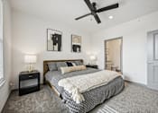 Thumbnail 12 of 59 - a bedroom with a bed and a ceiling fan at The Quarry Luxury Apartment Homes, Colorado, 80526