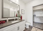 Thumbnail 14 of 59 - a white bathroom with a large mirror and a toilet at The Quarry Luxury Apartment Homes, Colorado, 80526
