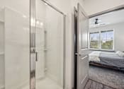 Thumbnail 16 of 59 - a bedroom with a bed and a glass closet at The Quarry Luxury Apartment Homes, Fort Collins, 80526
