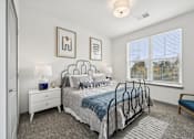 Thumbnail 17 of 59 - a bedroom with a bed and a large window at The Quarry Luxury Apartment Homes, Fort Collins, Colorado