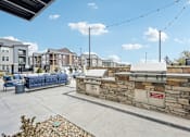 Thumbnail 38 of 59 - Outdoor patio with a grill and a seating area at The Quarry Luxury Apartment Homes, Fort Collins