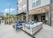 Thumbnail 37 of 59 - Outdoor community space with chairs barn doors and BBQ grills at The Quarry Luxury Apartment Homes, Fort Collins, Colorado
