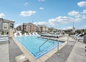 Thumbnail 43 of 59 - our apartments have a large pool with lounge chairs and umbrellas at The Quarry Luxury Apartment Homes, Fort Collins, CO