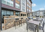 Thumbnail 40 of 59 - a patio with tables and chairs in front of a building at The Quarry Luxury Apartment Homes, Colorado