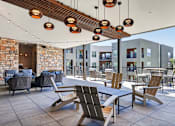 Thumbnail 31 of 32 - A patio with a table and chairs under a wooden beam.at Refinery at Pointe17 Apartments, Phoenix, AZ, 85085