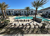 Thumbnail 1 of 40 - A pool surrounded by palm trees and lounge chairs.