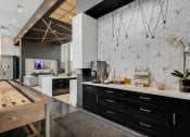 Thumbnail 27 of 31 - a large kitchen with black cabinets and white countertops and a large wooden table with a shuffle  at Prism at Diamond Ridge, Pennsylvania