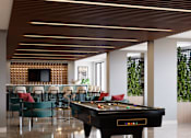 Thumbnail 4 of 21 - A pool table is in the middle of a room with a tv and chairs at Refinery at Pointe17 Apartments, Phoenix