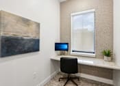 Thumbnail 18 of 20 - A room with a desk, chair, and a painting on the wall.