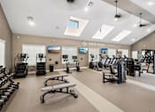 Thumbnail 3 of 20 - A gym with a variety of equipment including treadmills, exercise bikes, and weight machines.