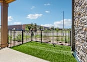 Thumbnail 16 of 20 - A view from a patio looking out to a grassy area and a building.