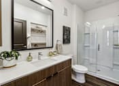 Thumbnail 10 of 20 - A bathroom with a white sink and a large mirror.
