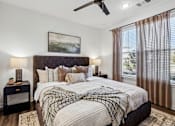 Thumbnail 8 of 20 - A bedroom with a large bed and a ceiling fan.