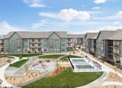 Thumbnail 32 of 56 - an exterior view of an apartment complex with a tennis court and a pool at Notch66, Longmont, Colorado