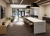 Thumbnail 15 of 35 - A modern kitchen with a long marble island and wooden chairs.