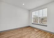 Thumbnail 37 of 58 - an empty room with wood flooring and a large window at Meridian at CityPlace, Woodbury, MN 55125