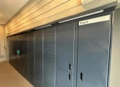 Thumbnail 57 of 88 - a set of blue lockers in a hallway of a building at The Depot, Raymore, 64083